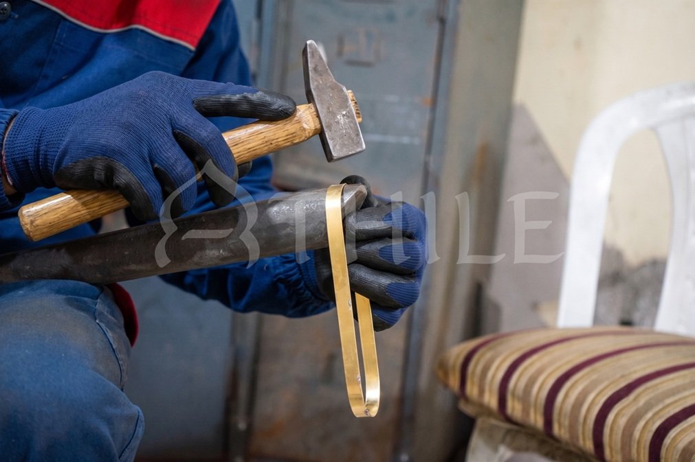Artisan shaping metal at the bench